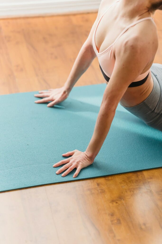 Eine Frau führt die Kobra Yogaübung aus. Hierfür werden komfortable und sichere Yoga Matten benötigt