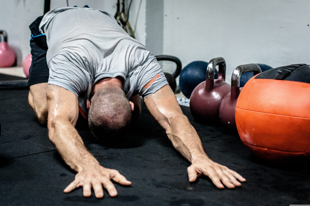 Ein Mann dehnt seinen unteren Rücken mit einer Yogaübung im Fitnessstudio